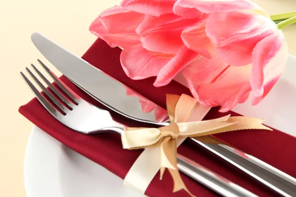 Tavolo da pranzo festivo con tulipani su sfondo beige — Foto Stock