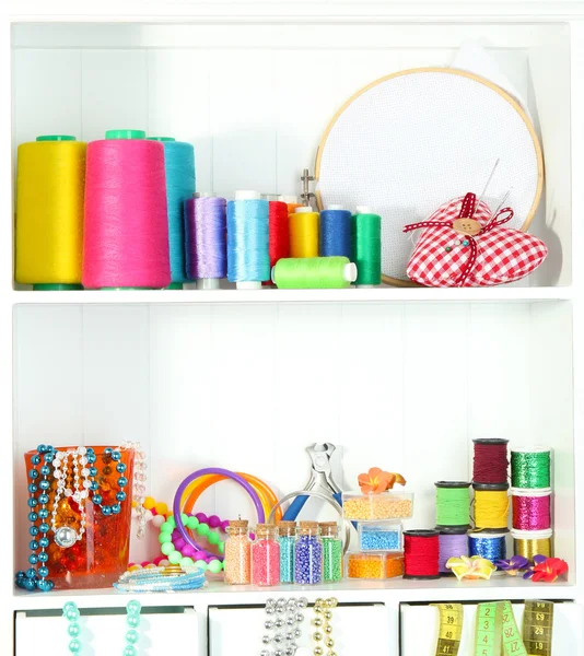 Beautiful white shelves with thread and material for handicrafts — Stock Photo, Image