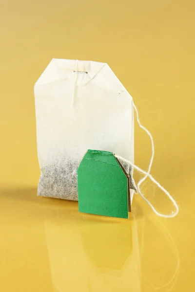 Tea bag on yellow background — Stock Photo, Image