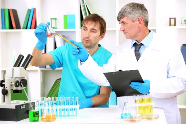 Médico y ensayador durante la investigación sobre el fondo de la habitación — Foto de Stock