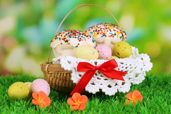 Gâteau de Pâques aux œufs dans un panier en osier sur herbe — Photo