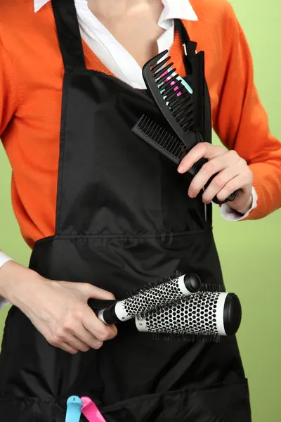 Hairdresser in uniform with working tools, on color background — Stock Photo, Image