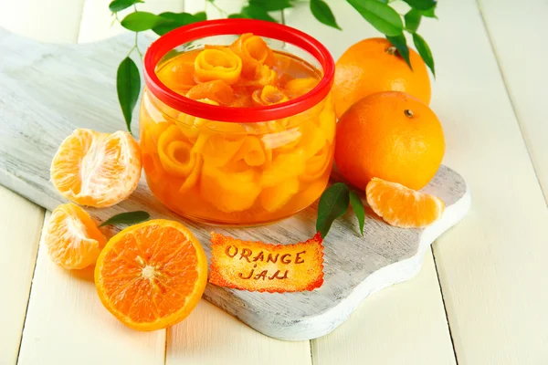 Engarrafamento de laranja com raspas e tangerinas, sobre mesa de madeira branca — Fotografia de Stock