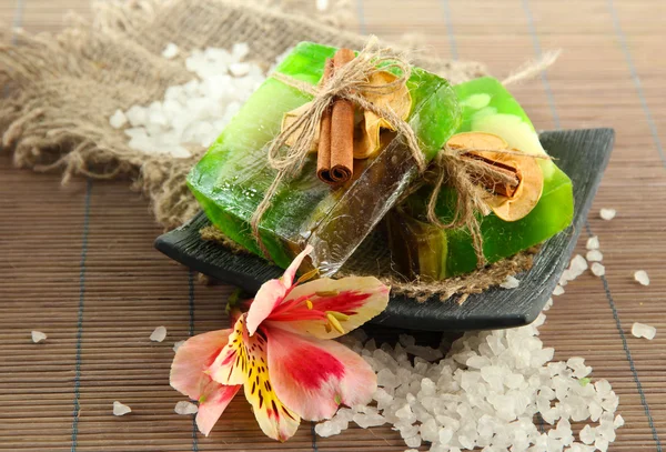 Sabão feito à mão e sal marinho em esteira de bambu cinza — Fotografia de Stock