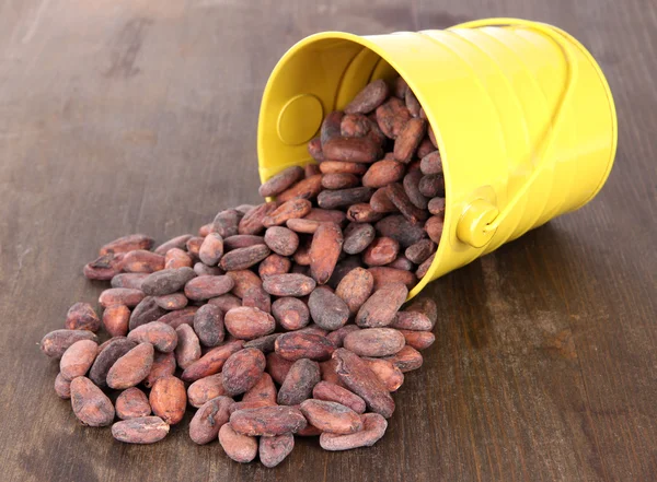 Overturned bucket with grains on wooden background — Stock Photo, Image