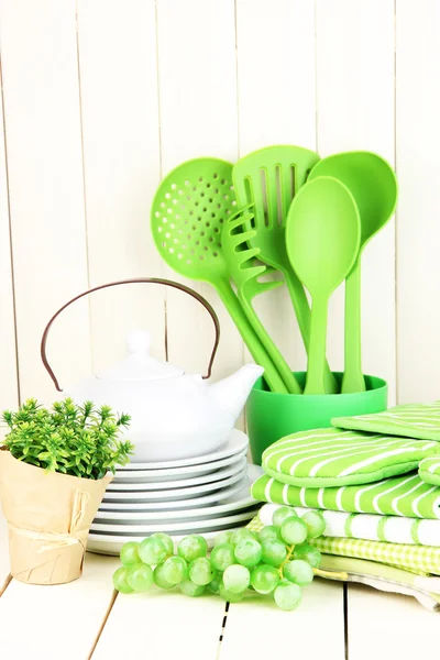 Kitchen settings: utensil, potholders, towels and else on wooden table — Stock Photo, Image