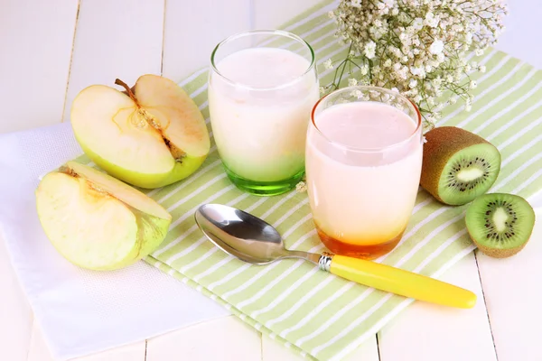 Köstliche Joghurts mit Früchten in Gläsern auf Holztisch in Großaufnahme — Stockfoto