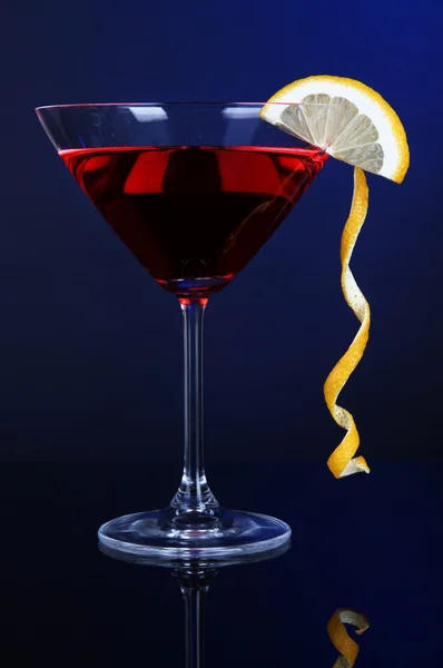 Red cocktail in martini glass on dark blue background — Stock Photo, Image