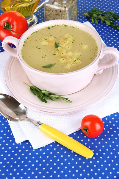 青のテーブル クロスのクローズ アップのピンクの鍋にスープを養う — ストック写真