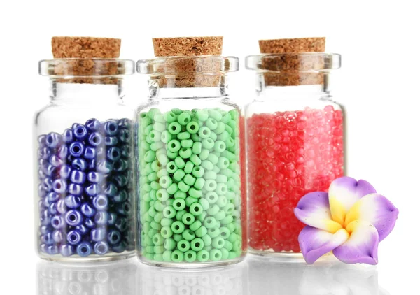 Kleine flessen vol met kleurrijke kralen geïsoleerd op wit — Stockfoto