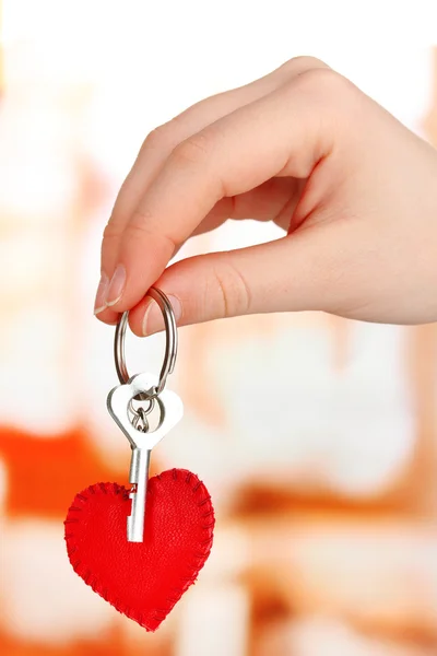 Schlüssel mit Lederschmuck in der Hand auf hellem Hintergrund — Stockfoto