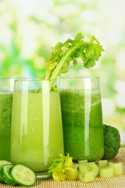 Bambu mat yeşil zemin üzerine yeşil sebze suyu bir bardak