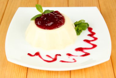 Panna cotta ahşap zemin üzerinde frambuaz sos ile