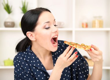 güzel kız mutfak zemin üzerine lezzetli pizza yemek istiyor