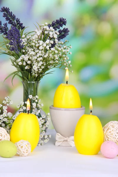 Пасхальные свечи с цветами на ярком фоне — стоковое фото