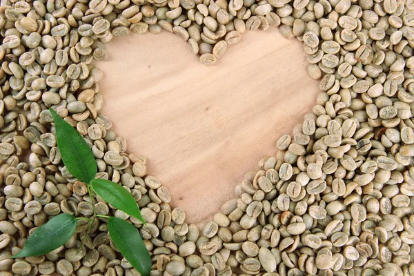 Chicchi di caffè verde e foglie su sfondo di legno — Foto Stock