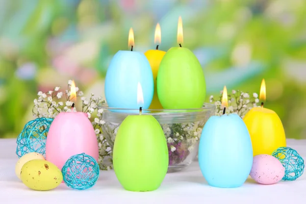 Easter candles with flowers on bright background — Stock Photo, Image