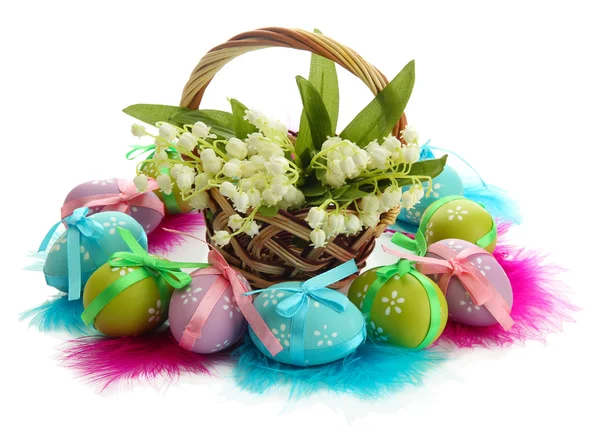 Hermosos huevos de Pascua y lirios del valle en cesta, aislados en blanco — Foto de Stock