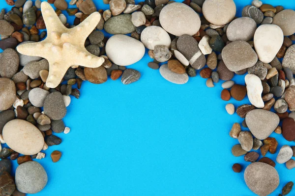 Frame of sea stones on color background — Stock Photo, Image