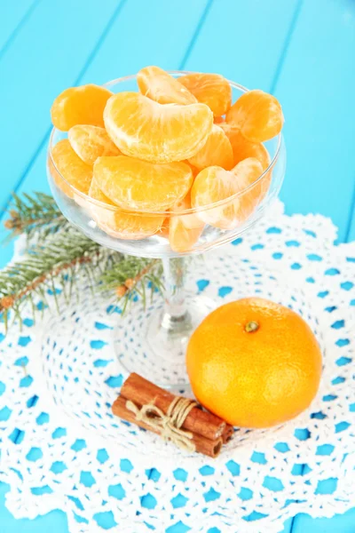 Sabrosas rebanadas de mandarina en tazón de vidrio sobre fondo azul — Foto de Stock