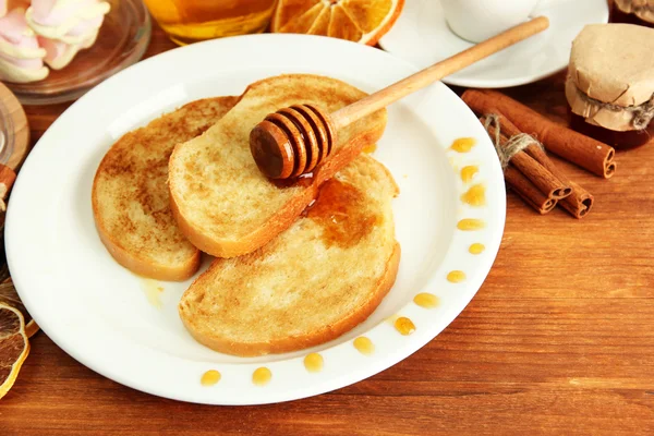 Torrada de pão branco com mel na mesa de madeira — Fotografia de Stock