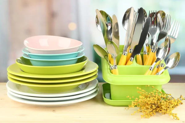 Тарелки, вилки, ножи, ложки и другие кухонные принадлежности на ярком фоне — стоковое фото