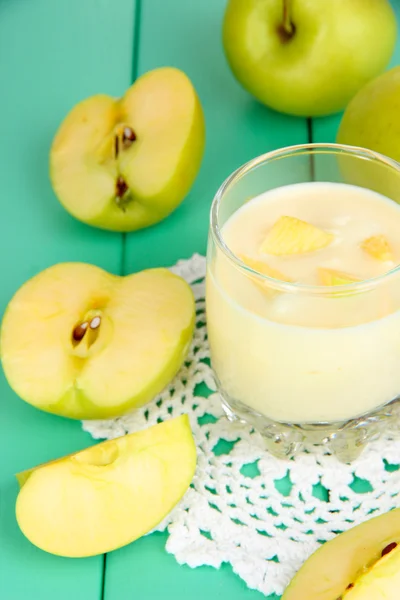 Delicious yogurt in glass with apple on wooden table close-up — Stock Photo, Image