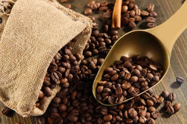 Kaffe i säck och scoop på träbord — Stockfoto