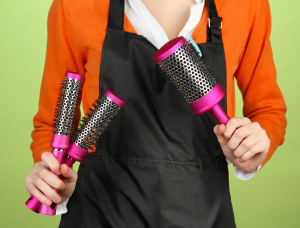 Hairdresser in uniform with working tools, on color background — Stock Photo, Image