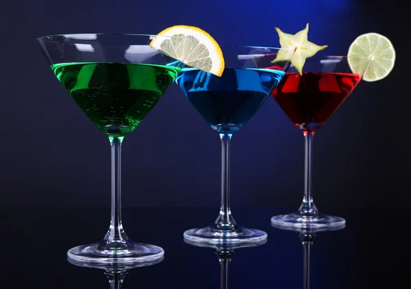 Koyu mavi zemin üzerine martini bardaklarda alkollü kokteyller — Stok fotoğraf
