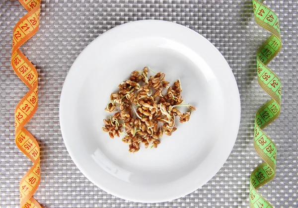 Wheat germs on plate and measuring tape, close up — Stock Photo, Image