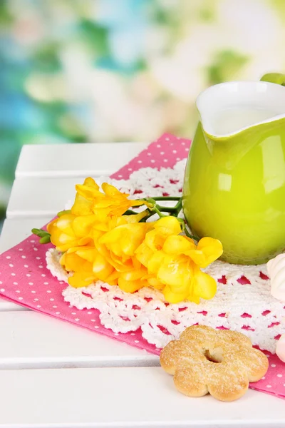 Mooie compositie van melk en koekjes op houten picknicktafel op natuurlijke achtergrond — Stockfoto