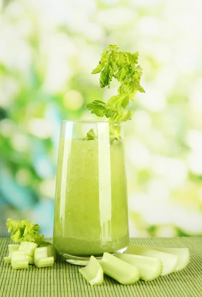 竹マット、緑の背景のセロリ ジュースのガラス — ストック写真