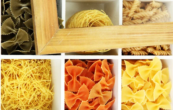 Různé druhy těstovin v bílý dřevěný box sekce detail — Stock fotografie