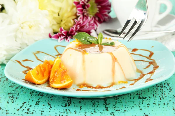 Panna Cotta com raspas de laranja e molho de caramelo, na cor de fundo de madeira — Fotografia de Stock