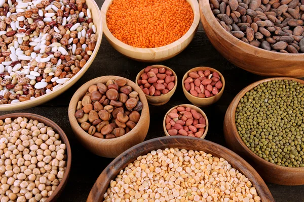 Different kinds of beans in bowls on table close-up — Stock Photo, Image