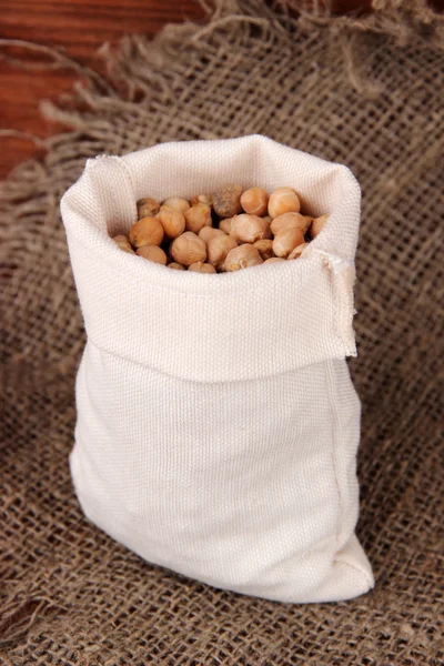 Beans in sack on wooden background — Stock Photo, Image