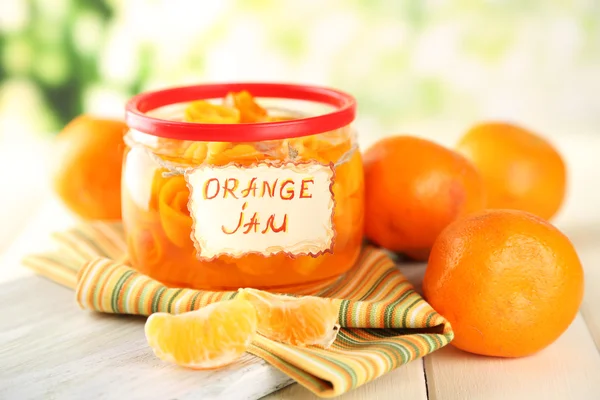 Orangenmarmelade mit Schale und Mandarinen, auf weißem Holztisch — Stockfoto