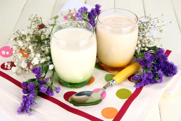 Смачні йогурти з фруктами в окулярах на дерев'яному столі крупним планом — стокове фото