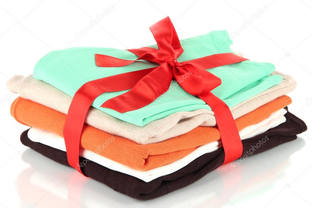 Pile of clothing with red ribbon and bow isolated on white