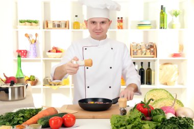 Şef mutfakta yemek yapıyor.