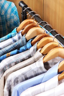 Gardıroptaki askılarda erkek gömlekleri.