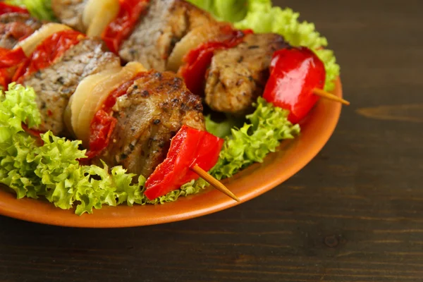 Carne la grătar și legume gustoase pe friptură pe farfurie, pe masă de lemn — Fotografie, imagine de stoc