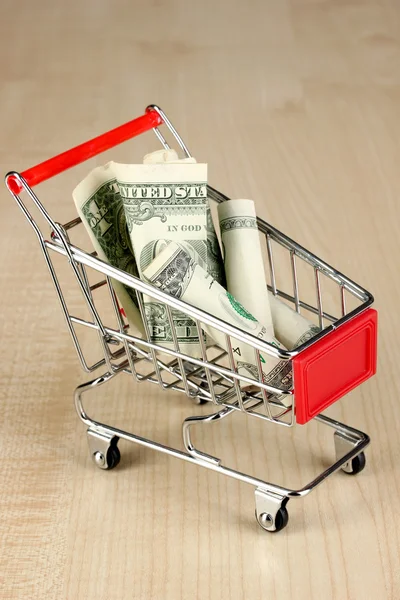 Geld im Einkaufswagen auf Holztisch in Großaufnahme — Stockfoto