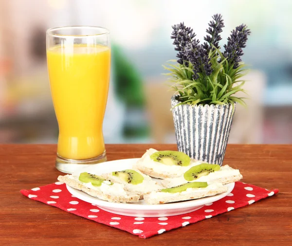 Gustose tartine con formaggio e kiwi, su piatto di colore, su sfondo brillante — Foto Stock