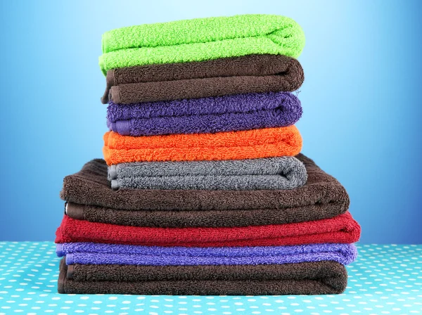 Pile of colorful towels, on blue background — Stock Photo, Image