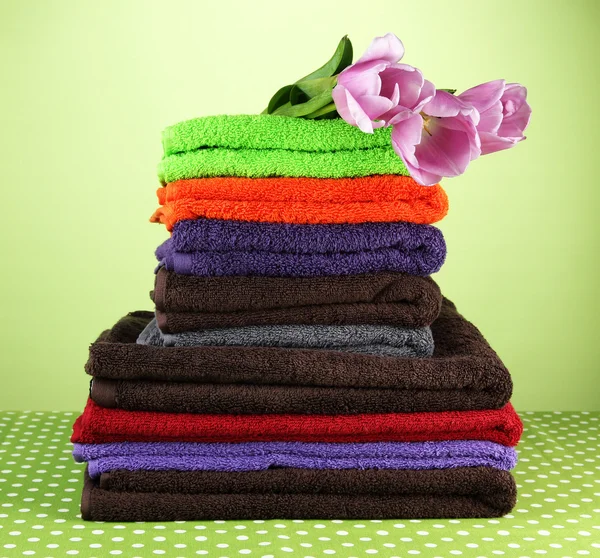 Pile of colorful towels, on green background — Stock Photo, Image