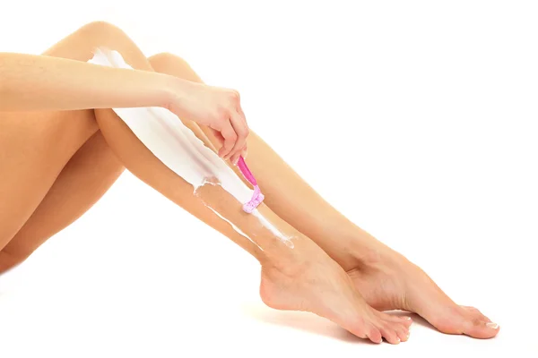 Hermosa mujer se afeita la pierna, aislada en blanco — Foto de Stock