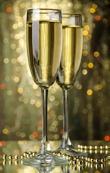 Two glasses of champagne on bright background with lights — Stock Photo, Image