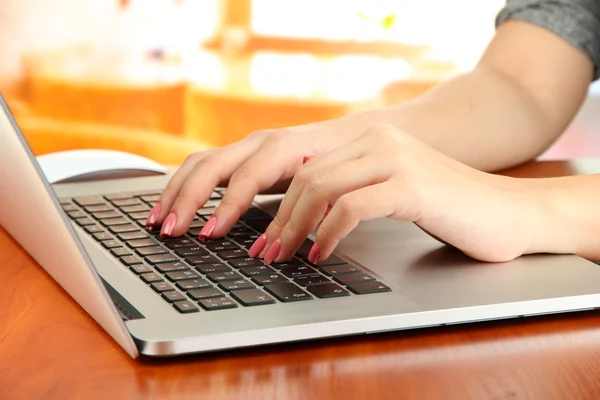 在笔记本电脑上，在明亮的背景上写的女性手 — 图库照片
